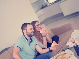 pareja comiendo pizza en su villa de lujo foto