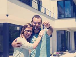 pareja abrazándose frente a una nueva casa de lujo foto