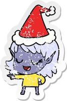 happy distressed sticker cartoon of a elf girl pointing wearing santa hat vector