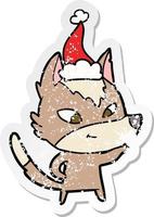 friendly distressed sticker cartoon of a wolf wearing santa hat vector