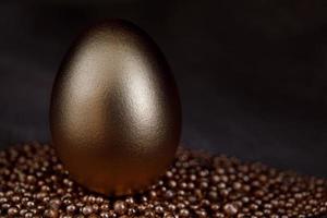 The golden egg stands on the gold sand. photo