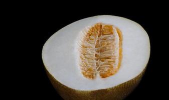 Cut melon on a black background. Half a melon. photo