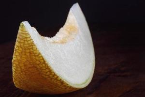 A piece of ripe melon on a wooden table. photo