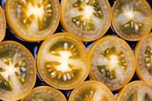 Background of yellow tomatoes cut into circles. photo