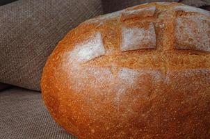 Loaf of round white bread on the background of linen cloth. photo