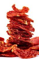 A stack of sun-dried tomatoes is isolated on a white background. photo