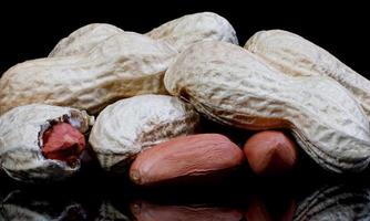 Peanuts in the shell and without it on a black background. photo