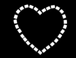 Heart lined with sugar cubes on a black background. photo