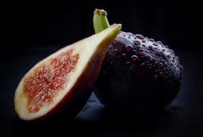 A whole half of figs. ripe figs with water drops on the peel. photo