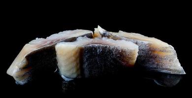 Three beautiful pieces of herring on a black background. Fillet of herring. photo