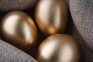 Three golden eggs are wrapped in cloth. photo