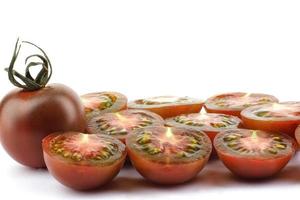 Whole and cut tomatoes. Black tomatoes. Cumato tomatoes. photo