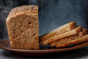 rebanadas de pan en un plato de cerámica. pan de masa fermentada. humo de fondo. foto