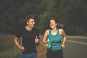 young couple jogging along a country road photo