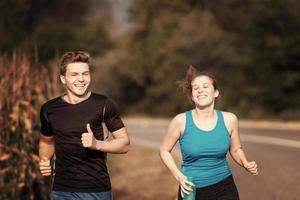 young couple jogging along a country road photo