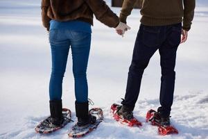 couple having fun and walking in snow shoes photo