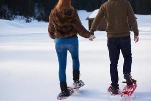 pareja divirtiéndose y caminando con raquetas de nieve foto