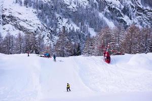 rescue team with a red helicopter rescuing a hurt skier photo