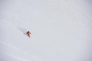 esquiador de freeride esquiando en nieve polvo profunda foto