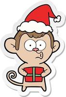 sticker cartoon of a christmas monkey wearing santa hat vector