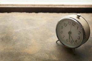 alarma de reloj vintage blanco cerca de la luz de la ventana. foto