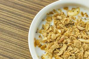 Morning food almond flakes  and milk in white bowl on wood table. photo