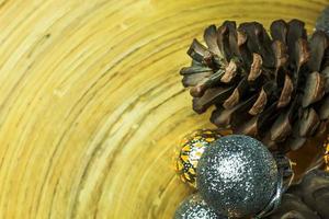 bola de navidad y conos de pino sobre fondo de madera. foto