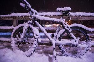 parked bicycle covered by snow photo