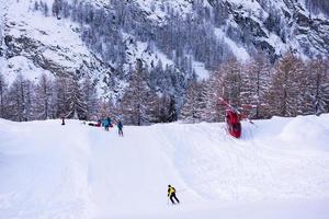 rescue team with a red helicopter rescuing a hurt skier photo