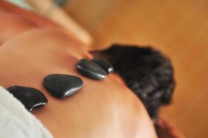 beautiful woman have hotstone massage at spa and wellness center photo