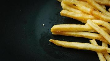 papas fritas en un plato negro para el contenido de alimentos. foto
