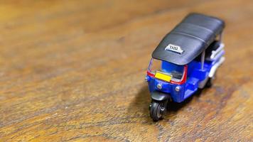 tuk tuk taxi  toy  on wood table close up image. photo