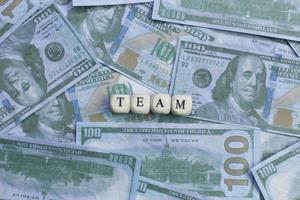 Team word on wood brick  background banknote. photo