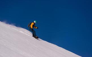 snowboarder running down the slope and ride free style photo