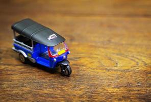 tuk tuk taxi  toy  on wood table close up image. photo