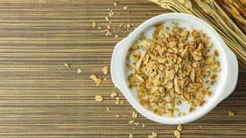 Morning food almond flakes  and milk in white bowl on wood table. photo