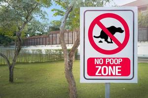 The Sign no poop zone close up image in  garden day light flare. photo