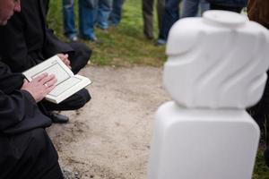 lectura del libro sagrado del corán por el imán en el funeral islámico foto