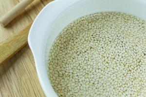 white Sesame seeds  on a old wooden table. photo