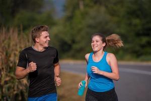 young couple jogging along a country road photo