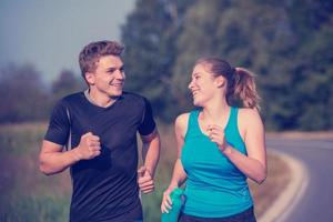 young couple jogging along a country road photo