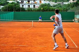 Man plays tennis outdoors photo