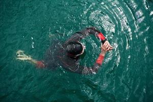 triathlon athlete swimming on lake setting smartwatch photo