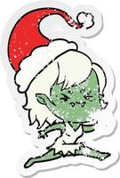 annoyed distressed sticker cartoon of a vampire girl wearing santa hat vector