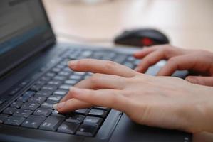 woman hands typing on laptop keyboard photo
