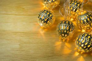 Christmas gold lights ball decor on wood table. photo