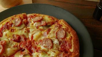 pizza en plato negro sobre mesa de madera para contenido de alimentos. foto