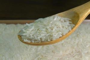 grano de arroz en la imagen de la mesa de madera para el fondo. foto