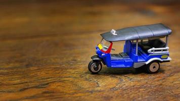 tuk tuk taxi  toy  on wood table close up image. photo