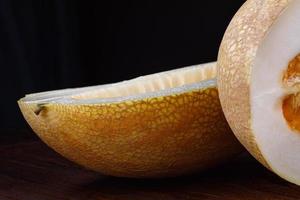 Cut ripe melon on a black background. photo